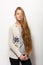 Human pose expressions and emotions. Young adorable redhead woman in cozy sweatshirt showing holding her gorgeous extra long