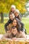 Human pyramid of five lying members of the family outdoors on an autumn day