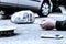 Human`s hand on the ground next to broke car mirror and mobile phone after a crash