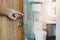 human`s hand opened wooden door to modern toilet