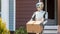 humanoid robot delivering a box to a house. future concept