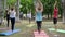 Humans practice yoga on mat, fitness warm-up in outdoor, yoga class outdoors, healthy lifestyle, wholesome women and men