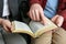 Humble couple reading Bible together, closeup. Religious literature