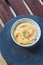 Hummus in a bowl, top view, grey and wooden background