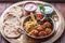 Hummus, falafel, salad and pita in a copper pan