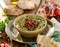 Hummus. Herbal hummus with the addition of pomegranate seeds, parsley, olive oil and aromatic spices in a ceramic pot on a wooden