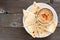 Hummus with pita bread on a plate, above view over wood