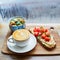 Hummus and tomato sandwich, salad and fresh hot cappuccino coffee