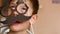 Humor on the theme of Father`s Day. A joking boy tries on a mask with a mustache and glasses, parodies a strict dad. The son turns