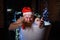 Humorous image of an evil santa claus taking a bath with christmas lights. A man with a red beard in a Santa Claus hat
