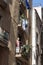 A humorous scene of a mannequin positioned on a balcony in the historic part of Barcelona, Spain