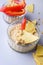 Humus Bowl with Nuts and Raw Pepper on the Blue Background Vertical Above Healthy Snack