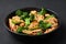 Hunan Chicken in black bowl at dark slate background. Chinese or indo-chinese cuisine takeaway dish