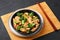 Hunan Chicken in black bowl at dark slate background. Chinese or indo-chinese cuisine takeaway dish