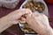 Hunan hands holding handful of walnuts over plastic table