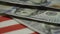 Hundred dollar banknotes fall on red and white flag stripes
