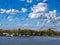 Hundreds of seagulls and pelicans flying under white clouds