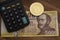 Hungarian forint 5000 forint banknote Count IstvÃ¡n Szechenyi Calculator on brown wooden table. Next to it is a gold bitcoin