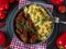 Hungarian goulash with buttered pasta on dark table. Flat lay