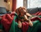 A Hungarian Vizsla reclines in a cozy nest of red and green blankets, eyes full of gentle warmth. Dog at home