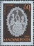 Hungary circa 1960: A post stamp printed in Hungary showing an ornate white halas lace work depicting a peacock against a brown ba