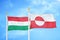 Hungary and Greenland two flags on flagpoles and blue cloudy sky