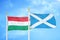 Hungary and Scotland two flags on flagpoles and blue cloudy sky