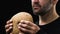 Hungry bearded man holding bread, poverty concept, social insecurity, close-up