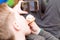 A Hungry boy eating a hot dog at home sit while playing with the smartphone.Close-up