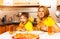 Hungry boy and his mother eating pizza in kitchen