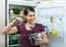 Hungry brunette standing near fridge