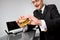 Hungry businessman eating hamburger