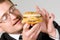 Hungry businessman eating hamburger