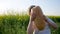 Hungry child eats food on meadow in backlight, youngster with loaf bread in hand on background field, little boy eating