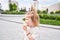 A hungry child enjoys eating ice cream outdoors. Portrait of a cute baby licking a creamy ice cream while walking in a