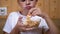 Hungry Child Hand Puts from the plate Chips in Mouth. Boy Eats Fast Food