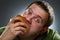 Hungry corpulent man eating white bread