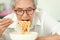 Hungry elderly woman eating instant noodles,fast food junk food High Sodium,Campaign for a low sodium diet,concept of healthy