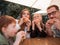 Hungry family eating hamburgers, sitting at a table in a fast food restaurant