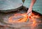 Hungry gold asian fish eats food from bottle in the pond. man`s hand. man feeds fish