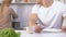 Hungry impatient husband holding knife and fork waiting for meal from slow wife