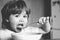 Hungry little boy eating. Baby eating food on kitchen. Happy baby boy eats healthy food spoon itself. Black and white