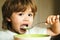 Hungry little boy eating. Cheerful baby child eats food itself with spoon. Tasty kids breakfast. Baby eating food on