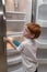 Hungry little boy looking into empty fridge