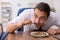 Hungry male employee eating buckwheat during break