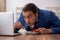 Hungry male employee eating buckwheat during break