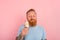 Hungry man with beard and tattoos eats a big icecream