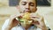 A hungry man eating a juicy burger in a fast food restaurant, delicious food