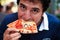 Hungry man eating slice of pizza