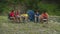 Hungry multiracial male tourists asking female friends to prepare camping food at campsite